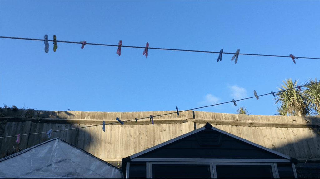 A colour photograph of two clothes lines cutting across a blue sky.