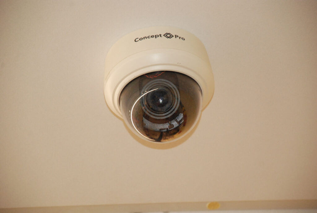 A colour photograph of a security camera installed on the ceiling.