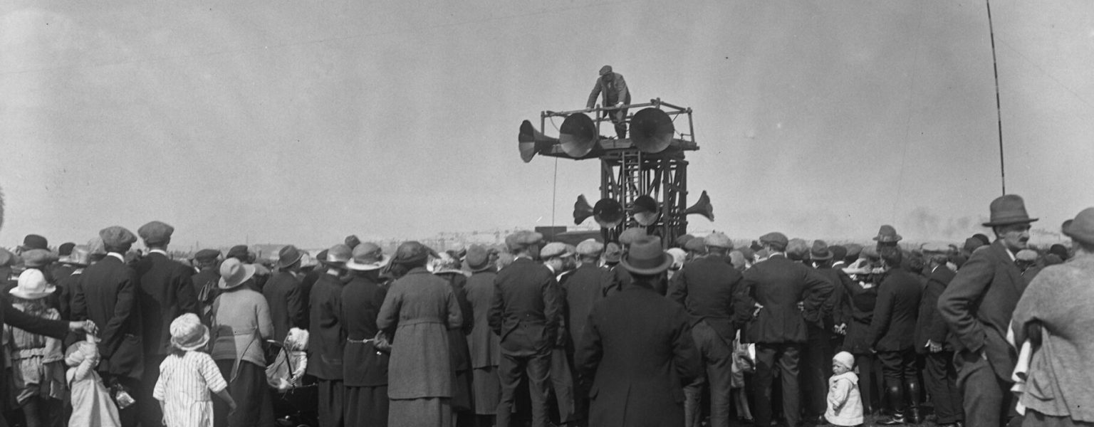 Black and white Sankey image of crowd gathering around speakers